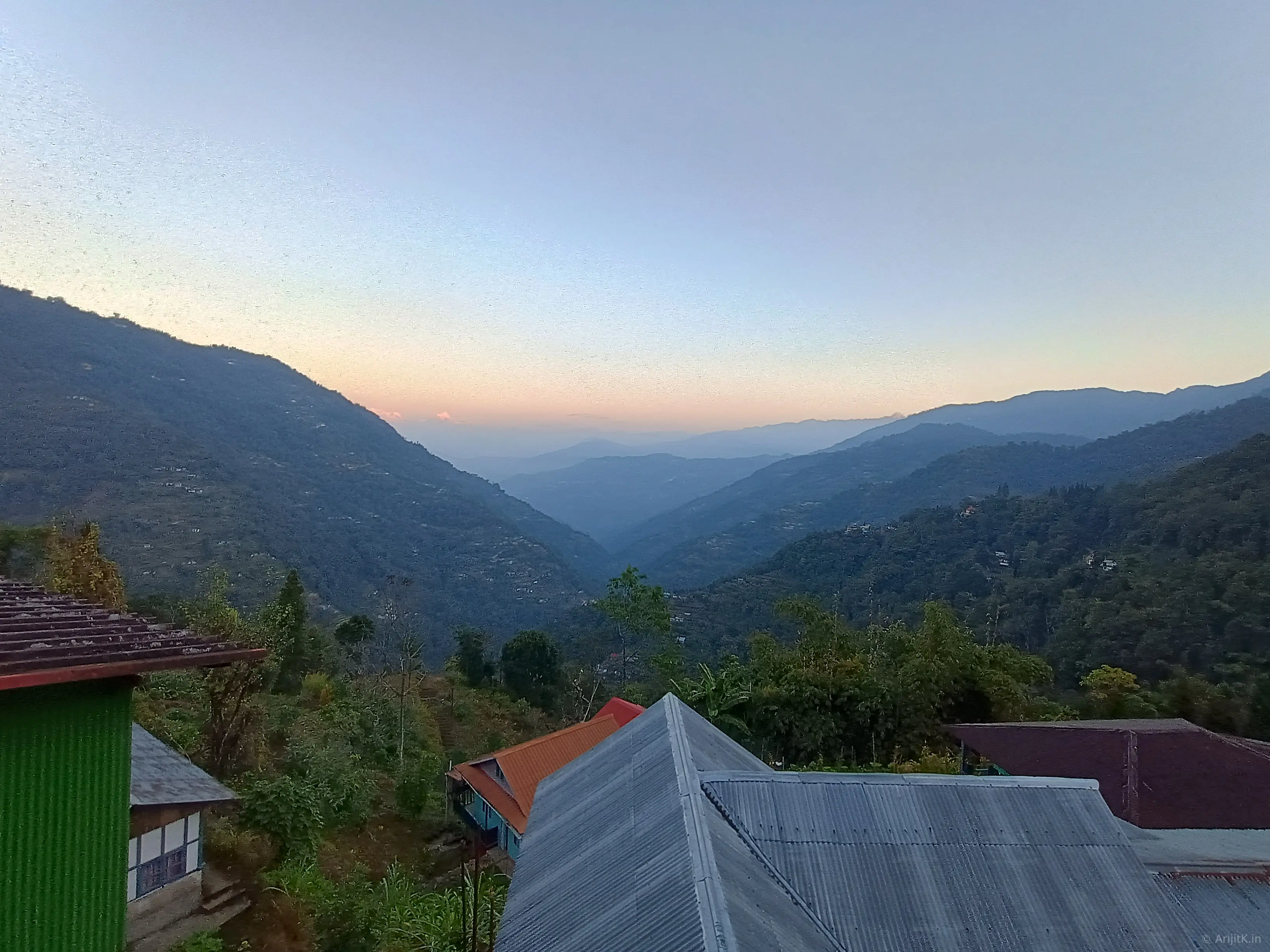 HDR shot of Kolakham at dawn with misty forested hills